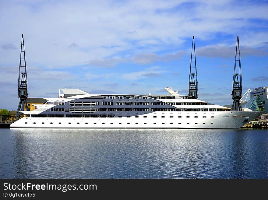 A large luxury yacht on the sea near the docks. A large luxury yacht on the sea near the docks.