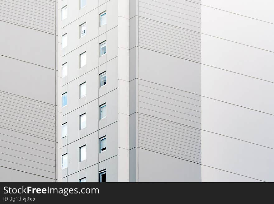 Background created by details of architecture of skyscraper showing windows and pale gray concrete panels in 3D. Background created by details of architecture of skyscraper showing windows and pale gray concrete panels in 3D.