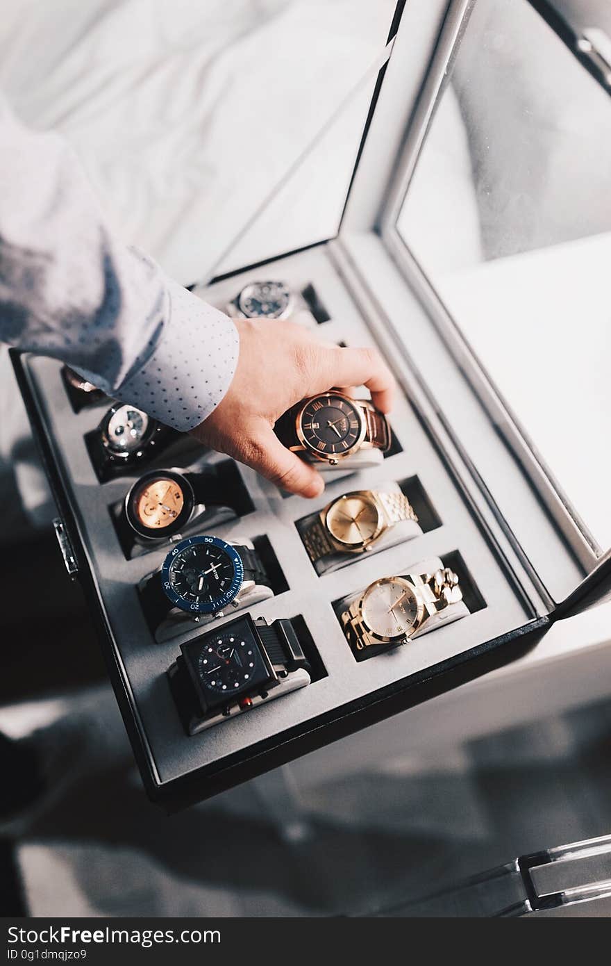 A man selecting a wrist watch from a box. A man selecting a wrist watch from a box.