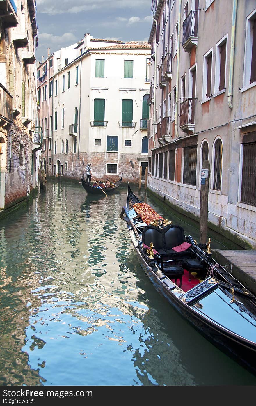 The water streets of Venice are canals which are navigated by gondolas and other small boats. During daylight hours the canals, bridges, and streets of Venice are full of tourists eager to experience the romance of this great travel destination. As night engulfs the town, tourists enjoy some fine dining at one of the many restaurants, leaving the waterways and streets quiet. The gondola is a traditional, flat-bottomed Venetian rowing boat, well suited to the conditions of the Venetian Lagoon. For centuries gondolas were once the chief means of transportation and most common watercraft within Venice. In modern times the iconic boats still have a role in public transport in the city, serving as ferries over the Grand Canal. They are also used in special regattas &#x28;rowing races&#x29; held amongst gondoliers. Their main role, however, is to carry tourists on rides throughout the canals. Gondolas are hand made using 8 different types of wood &#x28;fir, oak, cherry, walnut, elm, mahogany, larch and lime&#x29; and are composed of 280 pieces. The oars are made of beech wood. The left side of the gondola is longer than the right side. This asymmetry causes the gondola to resist the tendency to turn toward the left at the forward stroke. Venetian masks are a centuries-old tradition of Venice. The masks are typically worn during the Carnival of Venice, but have been used on many other occasions in the past, usually as a device for hiding the wearer&#x27;s identity and social status. The mask would permit the wearer to act more freely in cases where he or she wanted to interact with other members of the society outside the bounds of identity and everyday convention. It was thus useful for a variety of purposes, some of them illicit or criminal, others just personal, such as romantic encounters. The water streets of Venice are canals which are navigated by gondolas and other small boats. During daylight hours the canals, bridges, and streets of Venice are full of tourists eager to experience the romance of this great travel destination. As night engulfs the town, tourists enjoy some fine dining at one of the many restaurants, leaving the waterways and streets quiet. The gondola is a traditional, flat-bottomed Venetian rowing boat, well suited to the conditions of the Venetian Lagoon. For centuries gondolas were once the chief means of transportation and most common watercraft within Venice. In modern times the iconic boats still have a role in public transport in the city, serving as ferries over the Grand Canal. They are also used in special regattas &#x28;rowing races&#x29; held amongst gondoliers. Their main role, however, is to carry tourists on rides throughout the canals. Gondolas are hand made using 8 different types of wood &#x28;fir, oak, cherry, walnut, elm, mahogany, larch and lime&#x29; and are composed of 280 pieces. The oars are made of beech wood. The left side of the gondola is longer than the right side. This asymmetry causes the gondola to resist the tendency to turn toward the left at the forward stroke. Venetian masks are a centuries-old tradition of Venice. The masks are typically worn during the Carnival of Venice, but have been used on many other occasions in the past, usually as a device for hiding the wearer&#x27;s identity and social status. The mask would permit the wearer to act more freely in cases where he or she wanted to interact with other members of the society outside the bounds of identity and everyday convention. It was thus useful for a variety of purposes, some of them illicit or criminal, others just personal, such as romantic encounters.