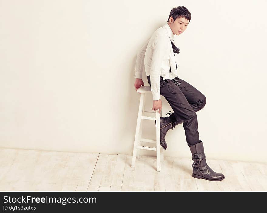 A boy in casual clothing posing on a chair. A boy in casual clothing posing on a chair.