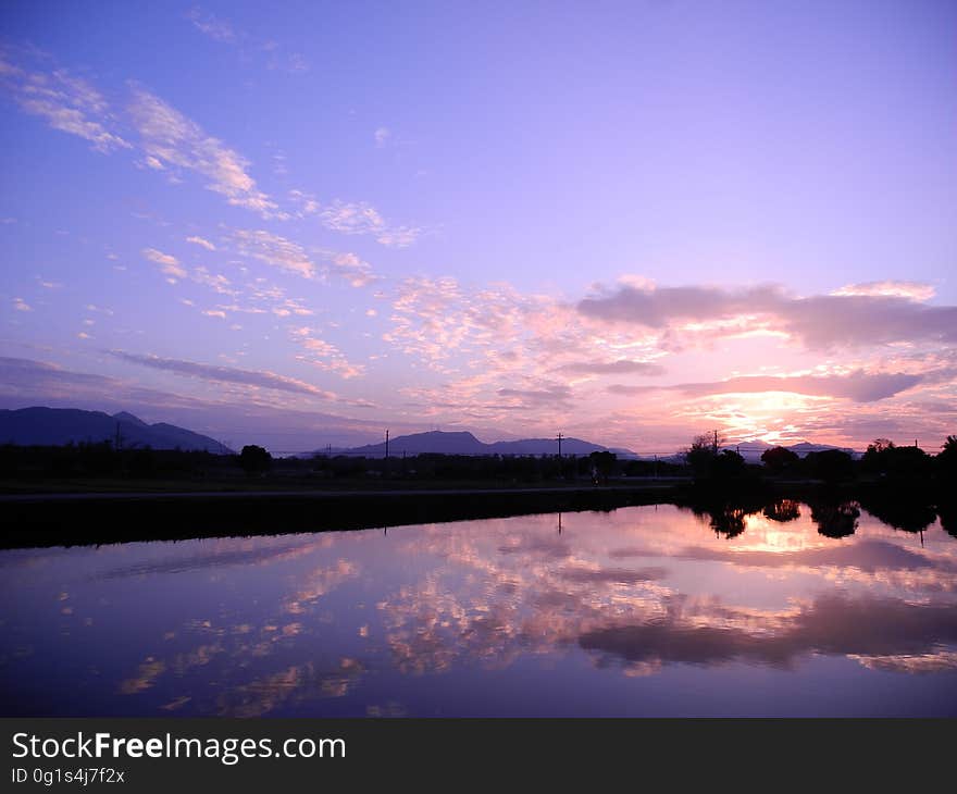 A sunset at lake with colorful skies reflecting in the water. A sunset at lake with colorful skies reflecting in the water.