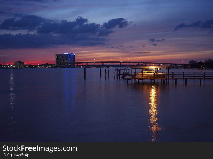 A sunset with a pier with a light. A sunset with a pier with a light.