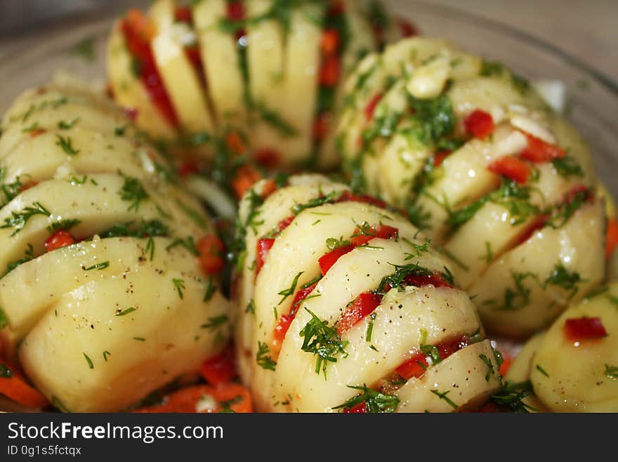 Hasselback potatoes with herbs and vegetables.