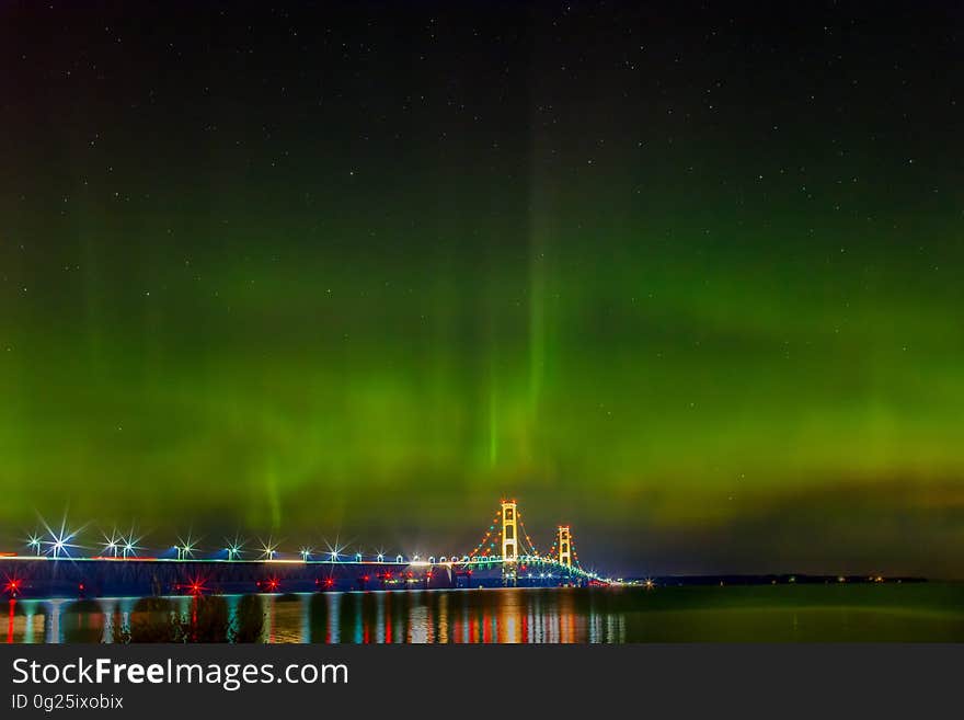 Aurora on the sky over a bridge with lights. Aurora on the sky over a bridge with lights.