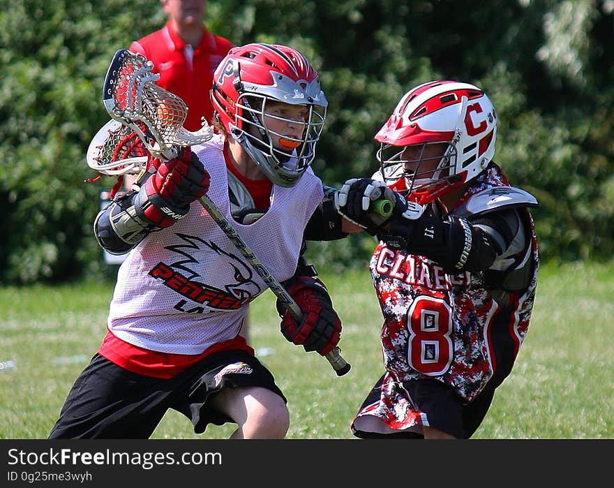 A pair of lacrosse players facing off during a game. A pair of lacrosse players facing off during a game.