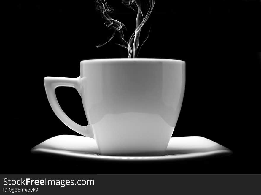 A cup of coffee with steam rising from it.