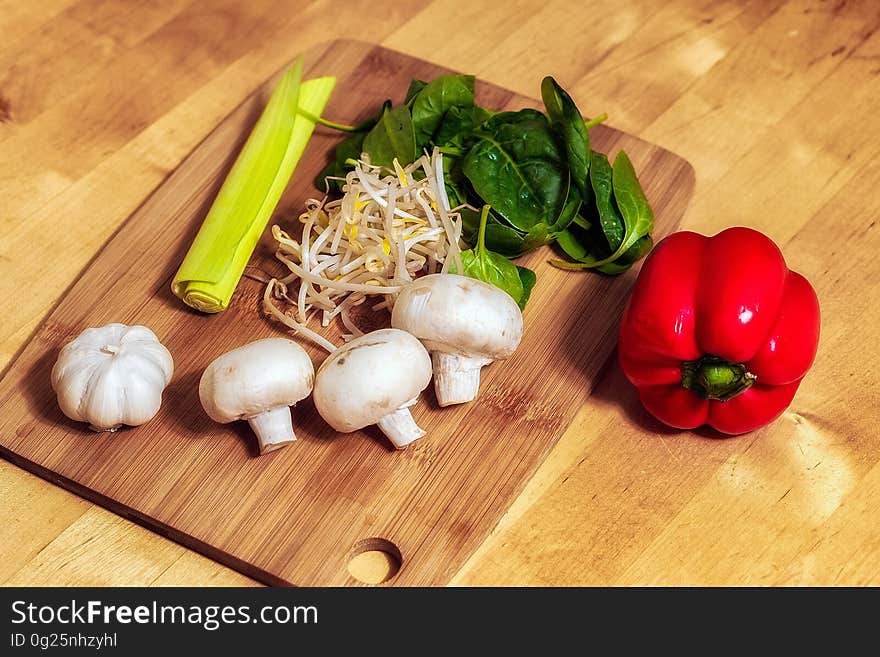 A cutting board with mushrooms and vegetables.