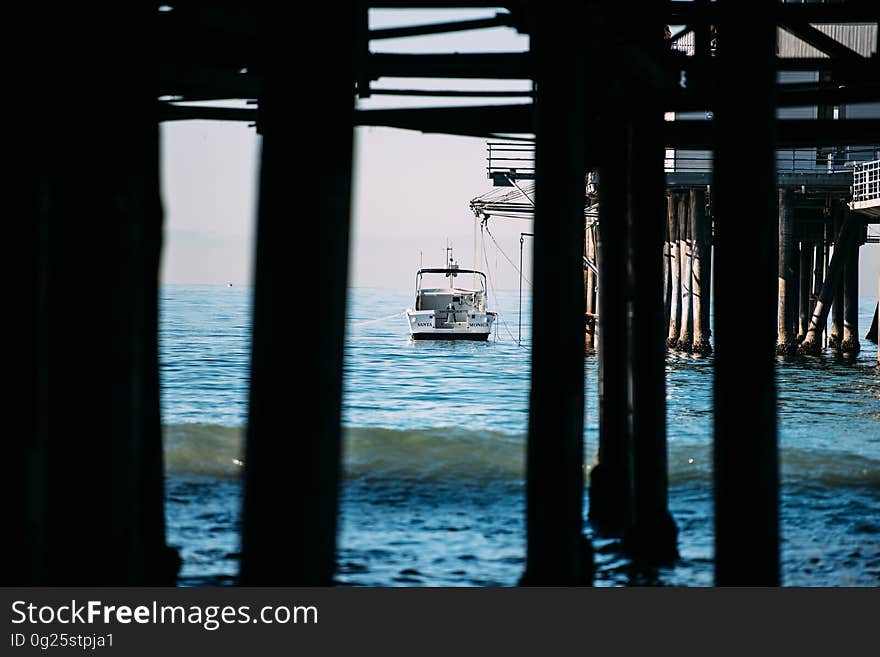 Seaside view which includes a pier and a jetty and small fishing or pleasure boat tied to the pier, background distant sea mist. Seaside view which includes a pier and a jetty and small fishing or pleasure boat tied to the pier, background distant sea mist.