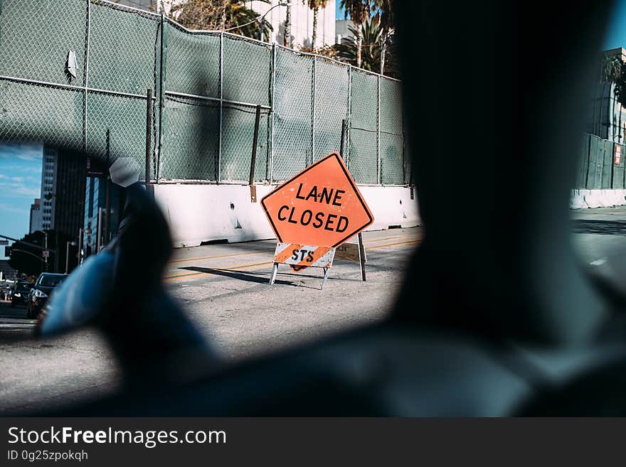 Lane closed construction sign viewed from motor car interior.