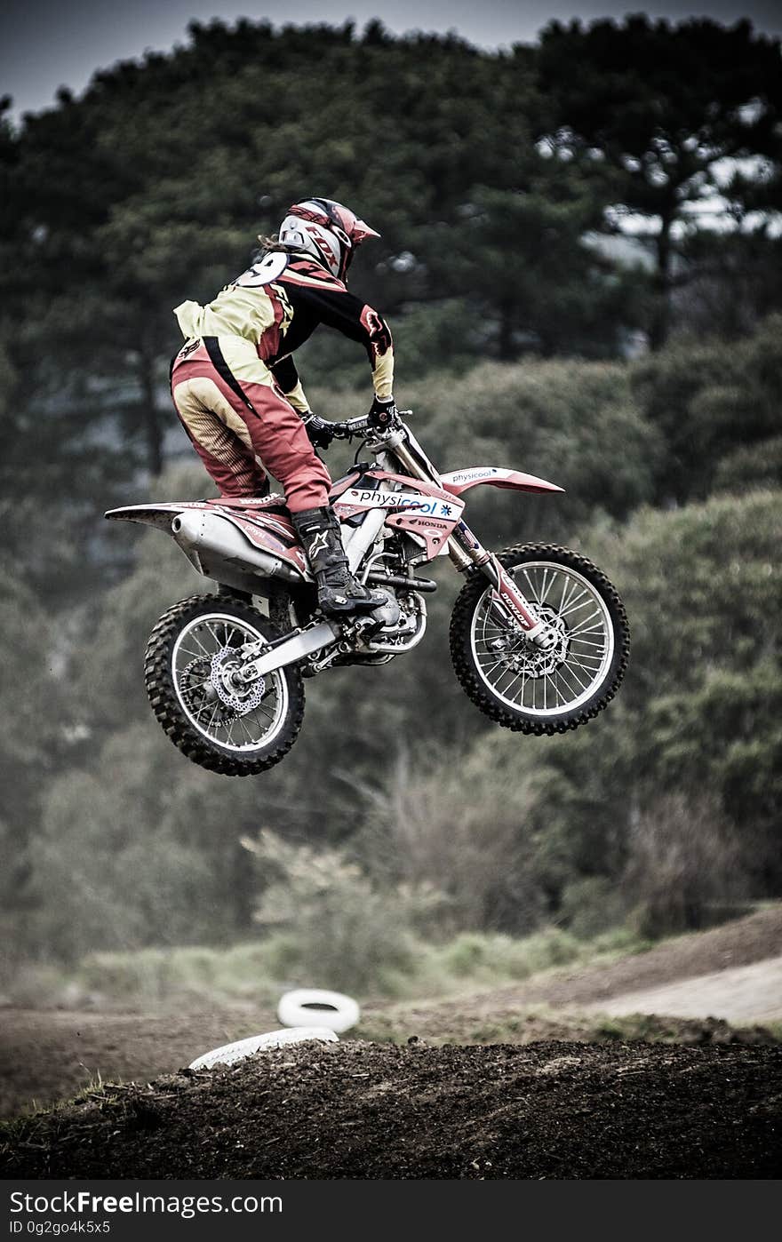 Motocross biker in safety uniform in air on dirt course. Motocross biker in safety uniform in air on dirt course.