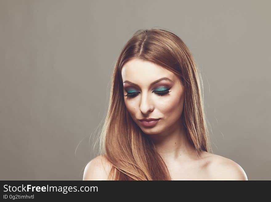 Indoor studio portrait of woman with long hair and bare chest.