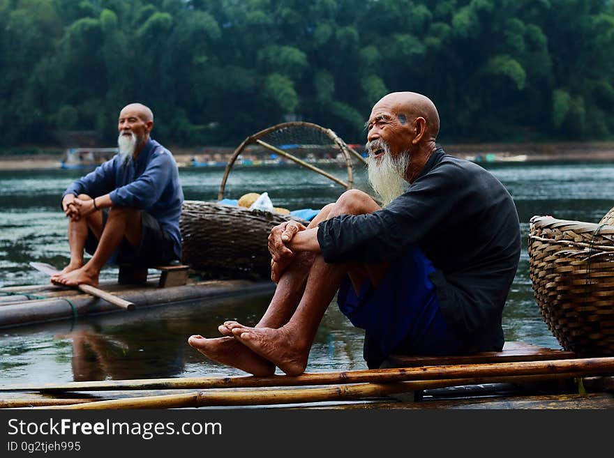 Two Men Sitting on Riverbank