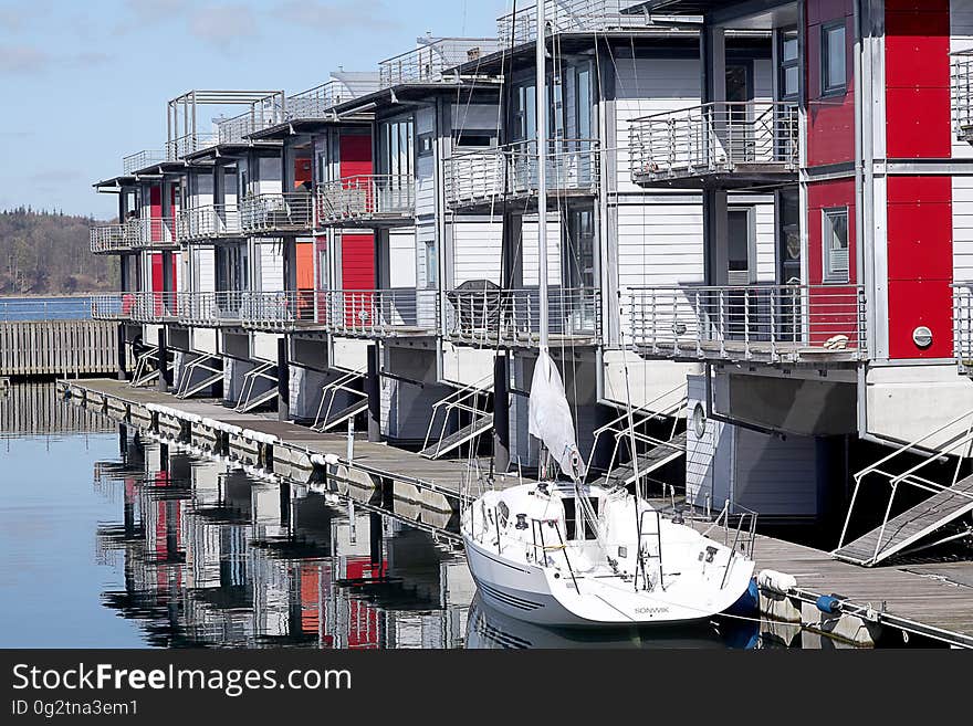 Boathouses with wooden pier and moored boat on sunny day. Boathouses with wooden pier and moored boat on sunny day.