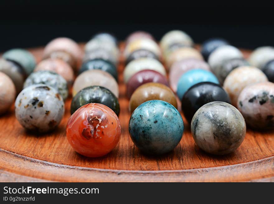 Close up of colorful marbles on wooden tray.