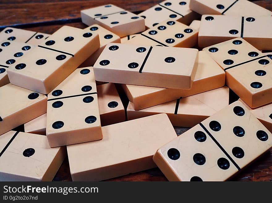 Close up of dominoes in pile on wood.