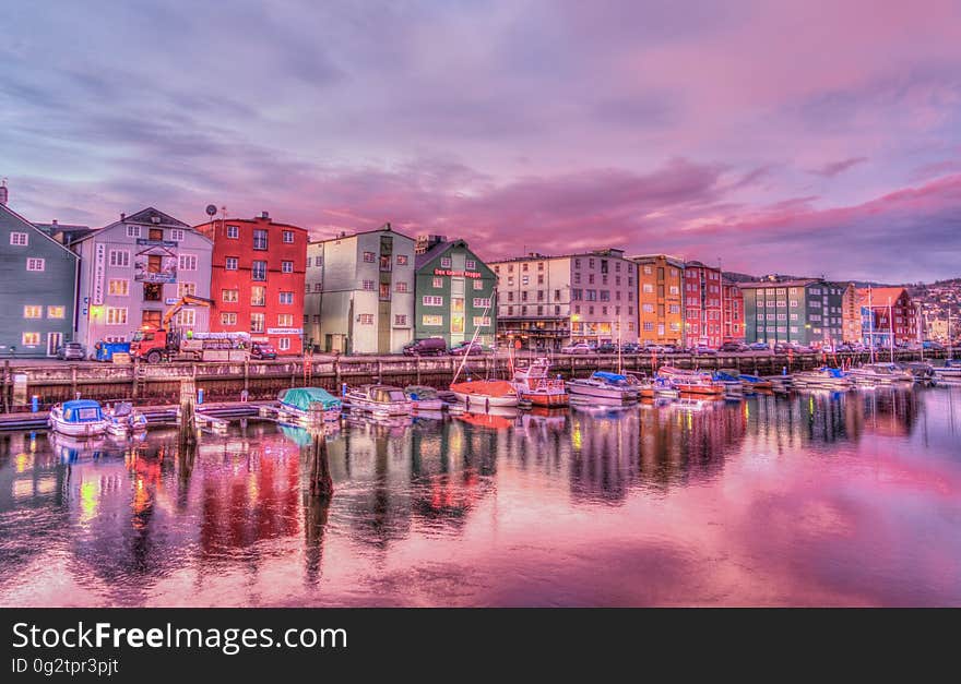 Coastal city reflecting in waterfront with boats at sunrise. Coastal city reflecting in waterfront with boats at sunrise.