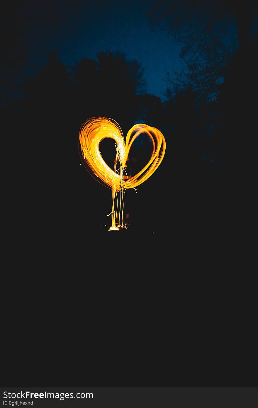 Gold heart shape tracing produced by a moving light source (torch for example) and extended exposure on a dark sky background. Gold heart shape tracing produced by a moving light source (torch for example) and extended exposure on a dark sky background.