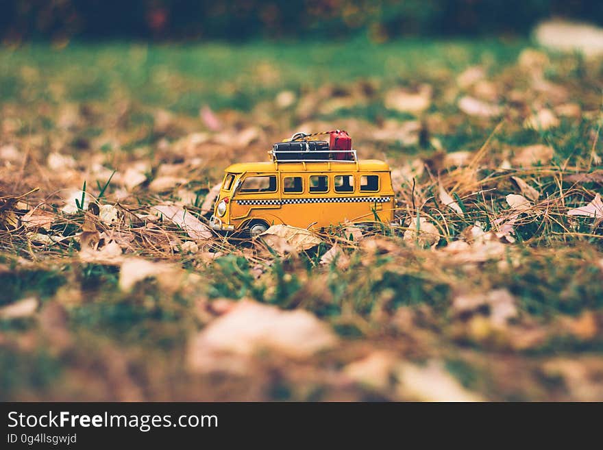 A toy minibus on green grass with fallen leaves. A toy minibus on green grass with fallen leaves.