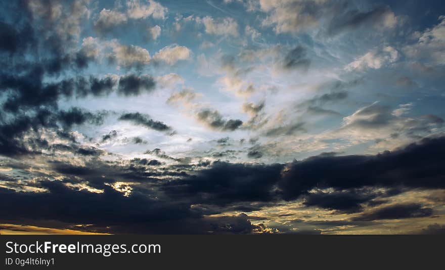 A blue sky with white clouds at sunset. A blue sky with white clouds at sunset.