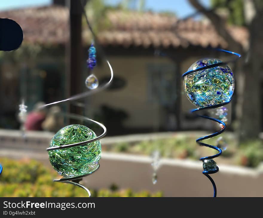 Close up of blue and green glass globes in metal lawn ornaments. Close up of blue and green glass globes in metal lawn ornaments.