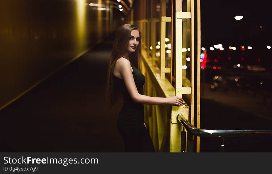 Portrait of woman standing in corridor illuminated at night. Portrait of woman standing in corridor illuminated at night.