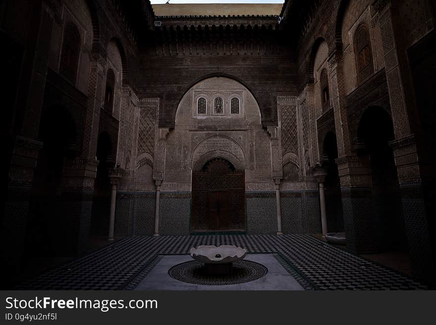 Fountain in outside courtyard of arched building in evening. Fountain in outside courtyard of arched building in evening.