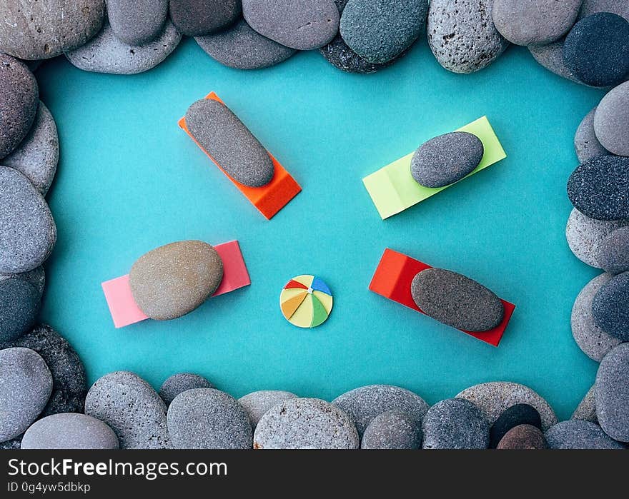 Rock art in shape of swimming pool with stones on rafts with beach ball. Rock art in shape of swimming pool with stones on rafts with beach ball.