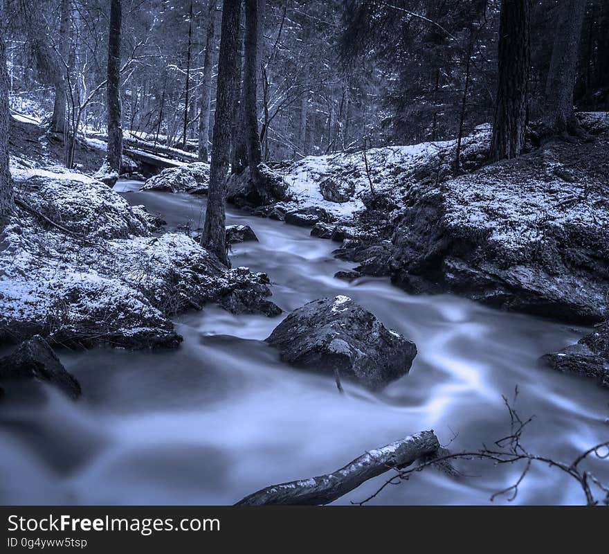 Blur of water in creek in snow covered forest. Blur of water in creek in snow covered forest.