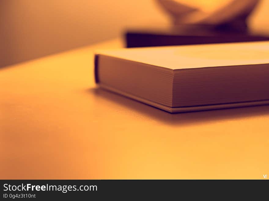 A close up of a closed book on a table. A close up of a closed book on a table.