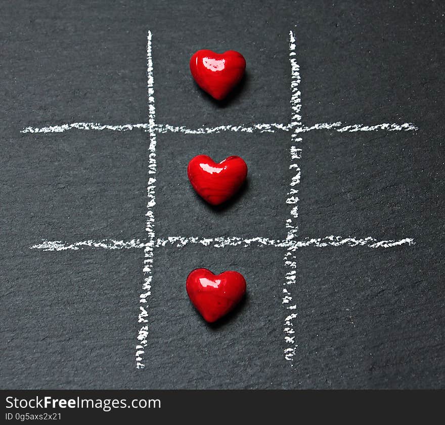 Three hearts on a tic tac toe board. Three hearts on a tic tac toe board.