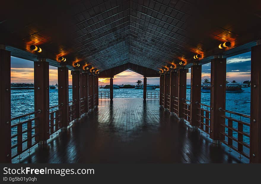 Wooden pier into blue waters at sunset. Wooden pier into blue waters at sunset.