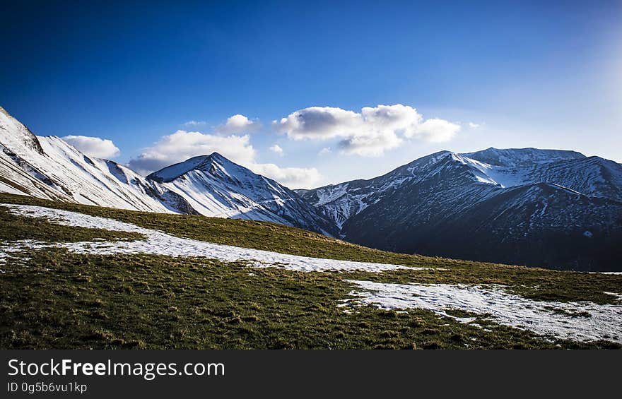 Mountain slopes and peaks partly covered in snow.