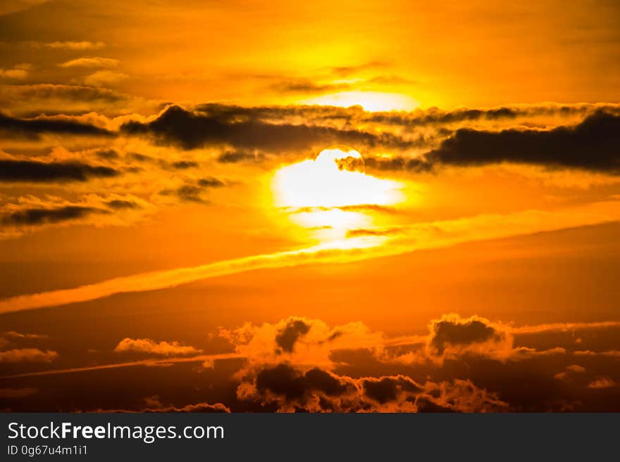 Orange sun in cloudy skies at sunset. Orange sun in cloudy skies at sunset.