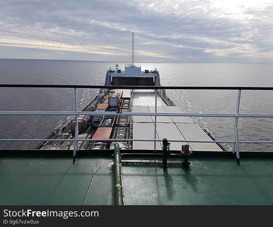 A cargo container ship on the seas seen from the deck.