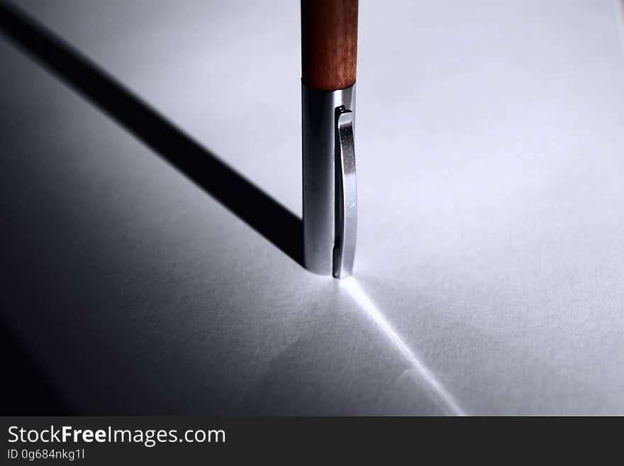 A close up of a pen and its shadow on a table.