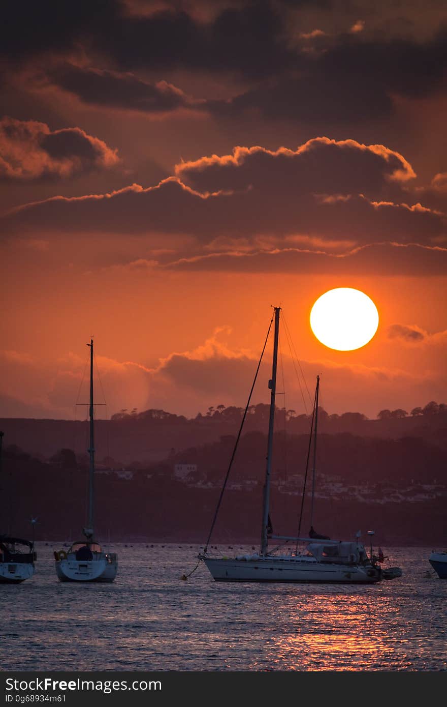 Sunset in orange skies over sailboats in marina. Sunset in orange skies over sailboats in marina.