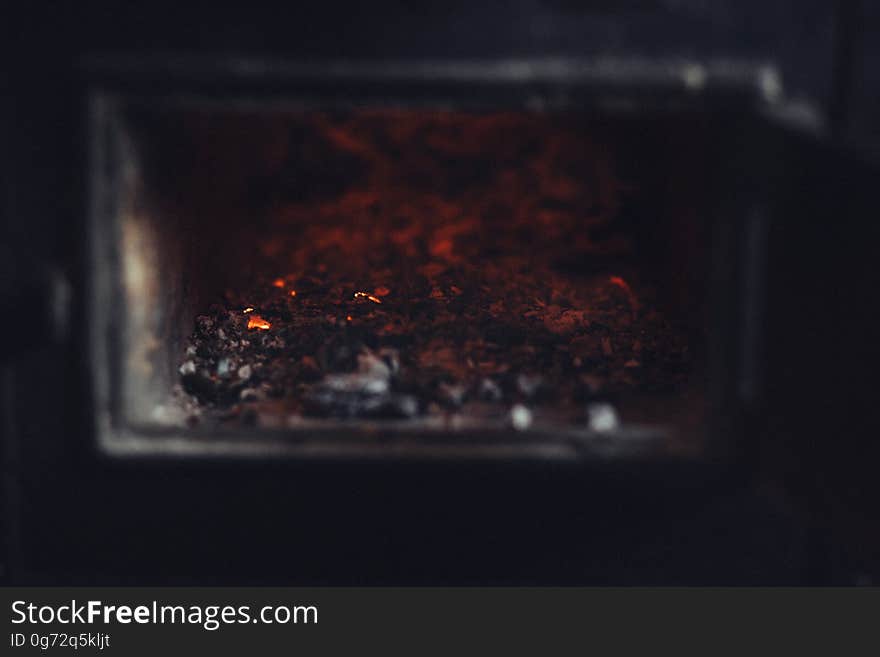 Glow of burning coal embers in fireplace.