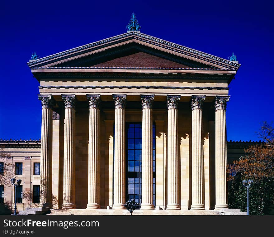 Pillars on front of stone building against blue skies on sunny day. Pillars on front of stone building against blue skies on sunny day.