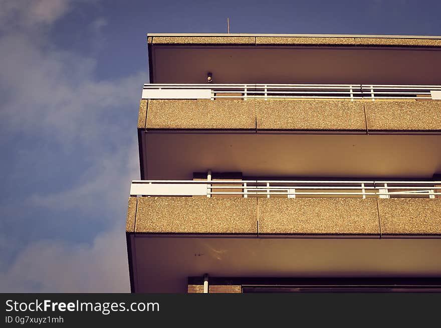 Exterior balconies on front of building against cloudy blue skies. Exterior balconies on front of building against cloudy blue skies.