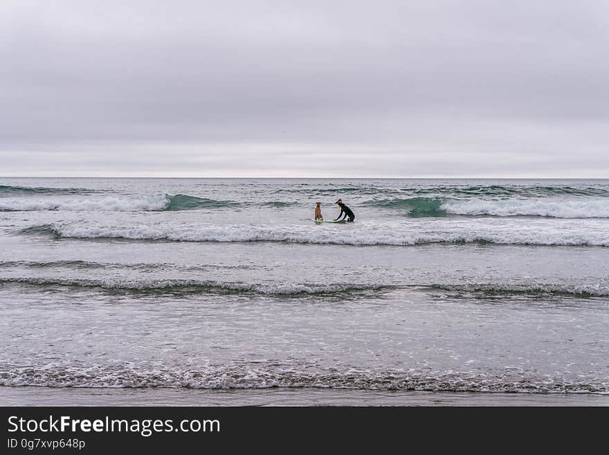 Surfers in shallow water and open sea in the background. Surfers in shallow water and open sea in the background.