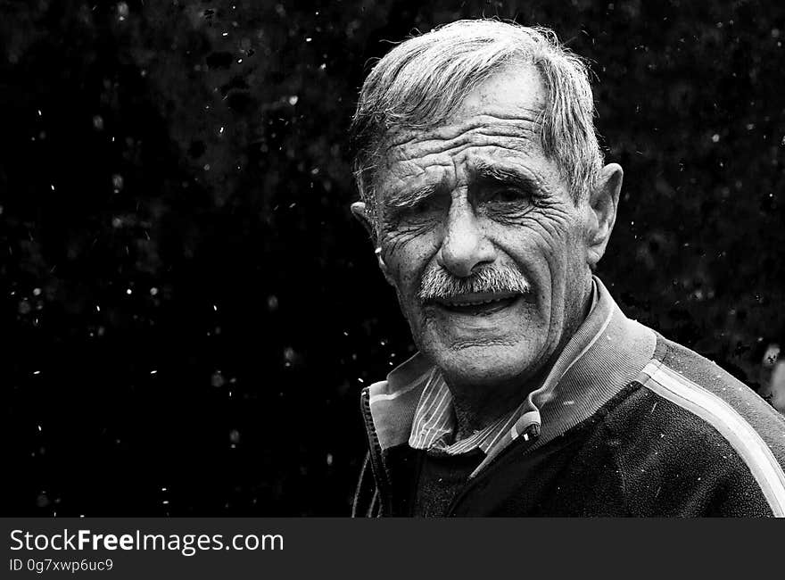 A black and white portrait of a surprised elderly man with a mustache.