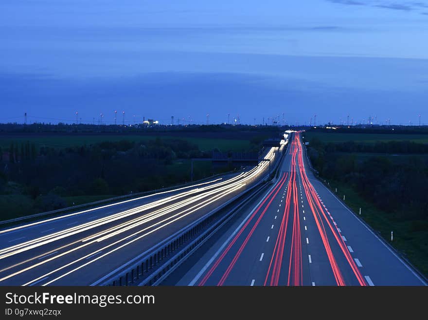 Blur of headlights and taillights on rural roadway at twilight. Blur of headlights and taillights on rural roadway at twilight.