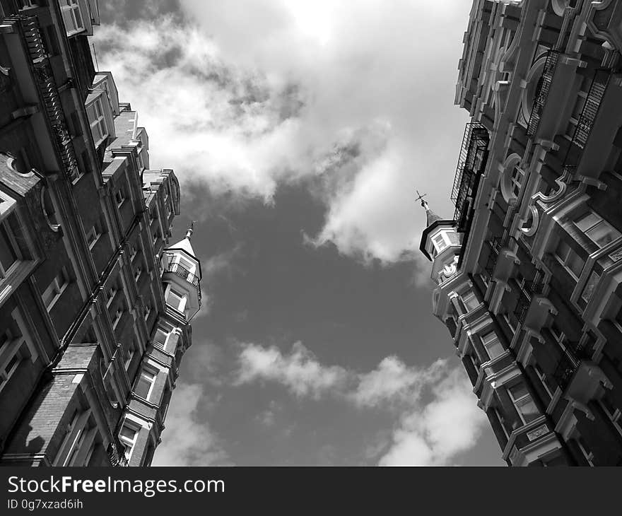 A black and white photo of residential buildings from a low angle. A black and white photo of residential buildings from a low angle.