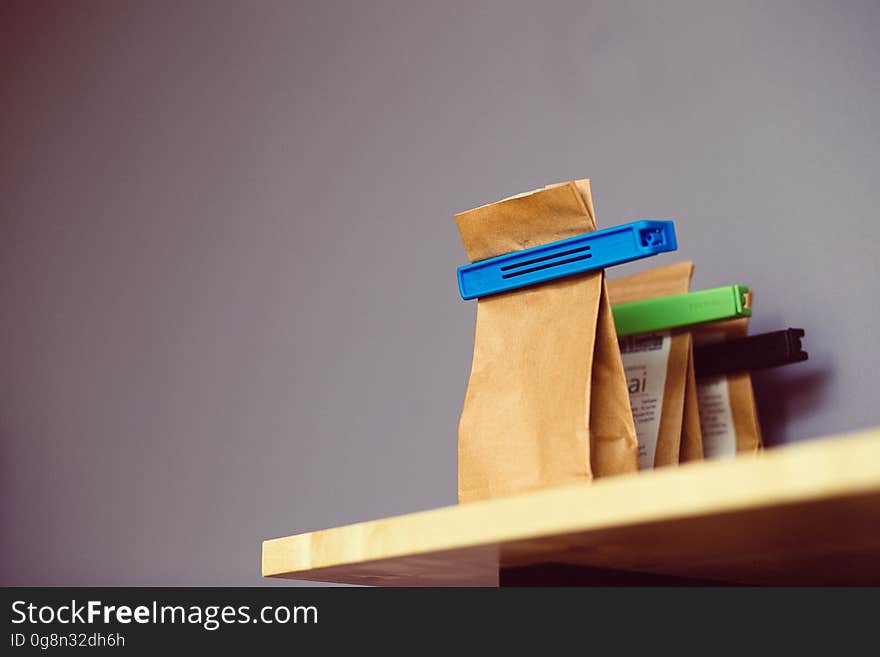 Paper bags with colorful clips on wooden tabletop.