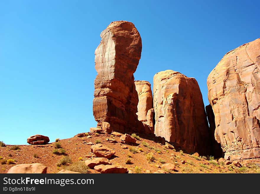 Sandstone rock formation in desert against blue skies on sunny day.