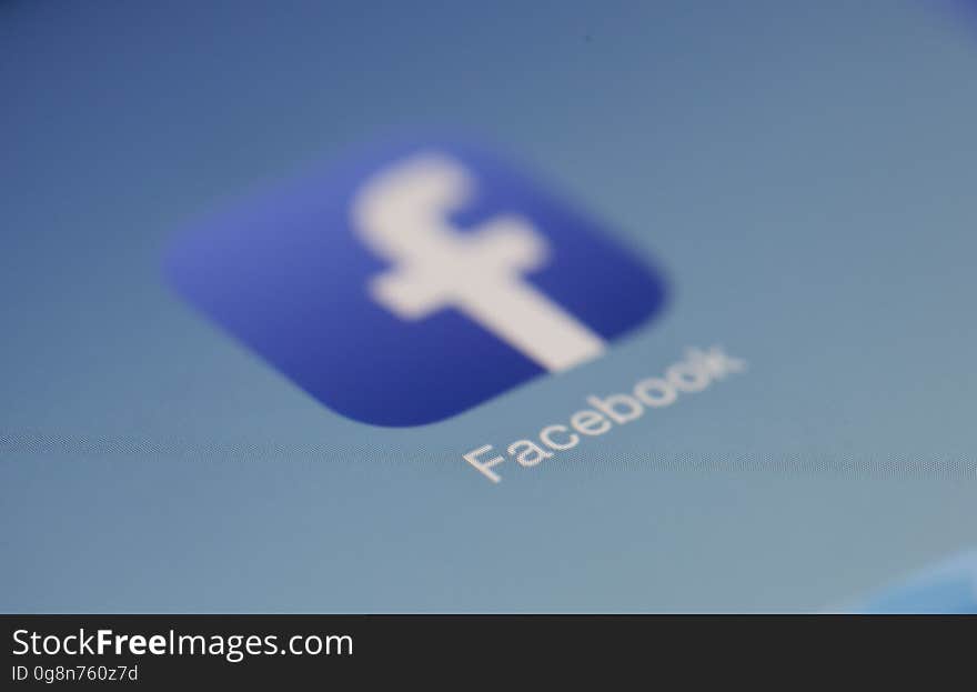 A blurred Facebook logo on a blue background.