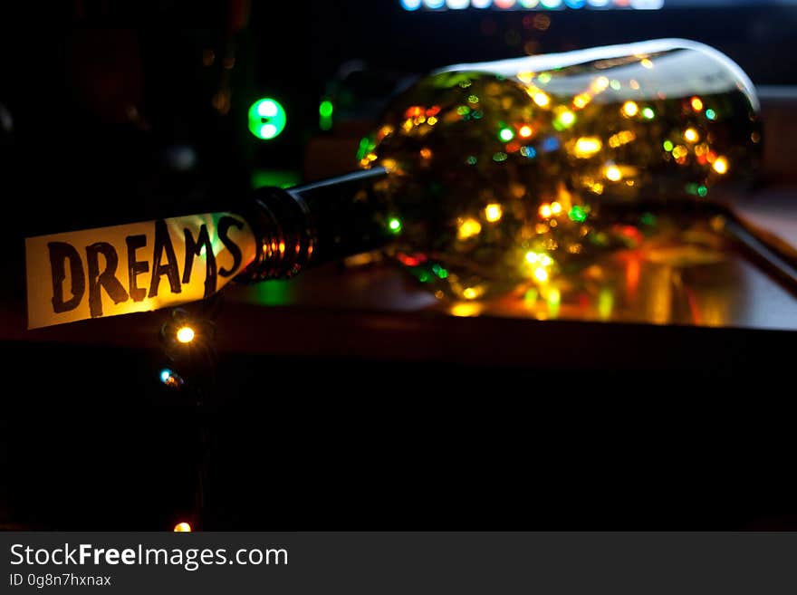 A bottle with Christmas lights inside and a note saying "Dreams" on the top. A bottle with Christmas lights inside and a note saying "Dreams" on the top.