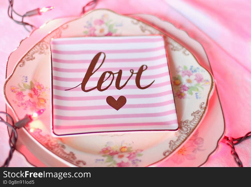 A pink striped plate with the text love and a heart symbol. A pink striped plate with the text love and a heart symbol.