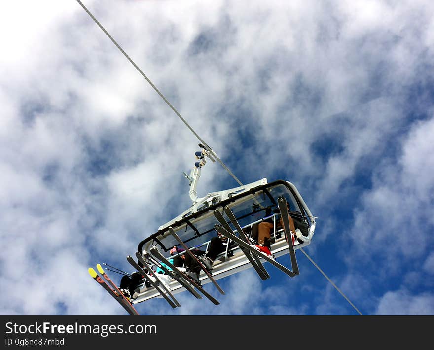 A chairlift with skiers from a low angle.